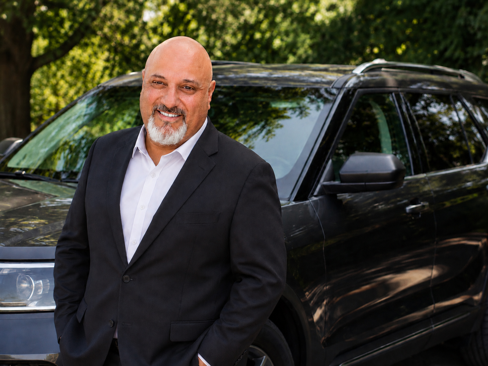 Joel Wulkan, owner of Flight Rides LLC, standing beside a black private transportation SUV